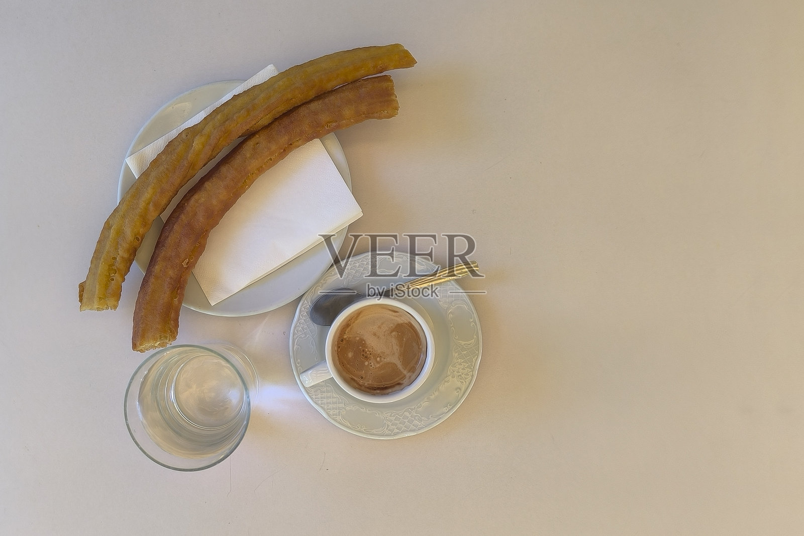 马德里特色的早餐：咖啡、油条和涂抹天然番茄的烤面包。照片摄影图片