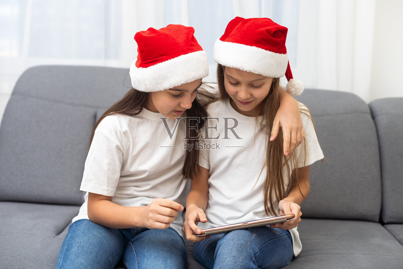 新年概念。圣诞节，冬季，幸福概念 - 两个可爱的女孩在玩平板电脑照片摄影图片