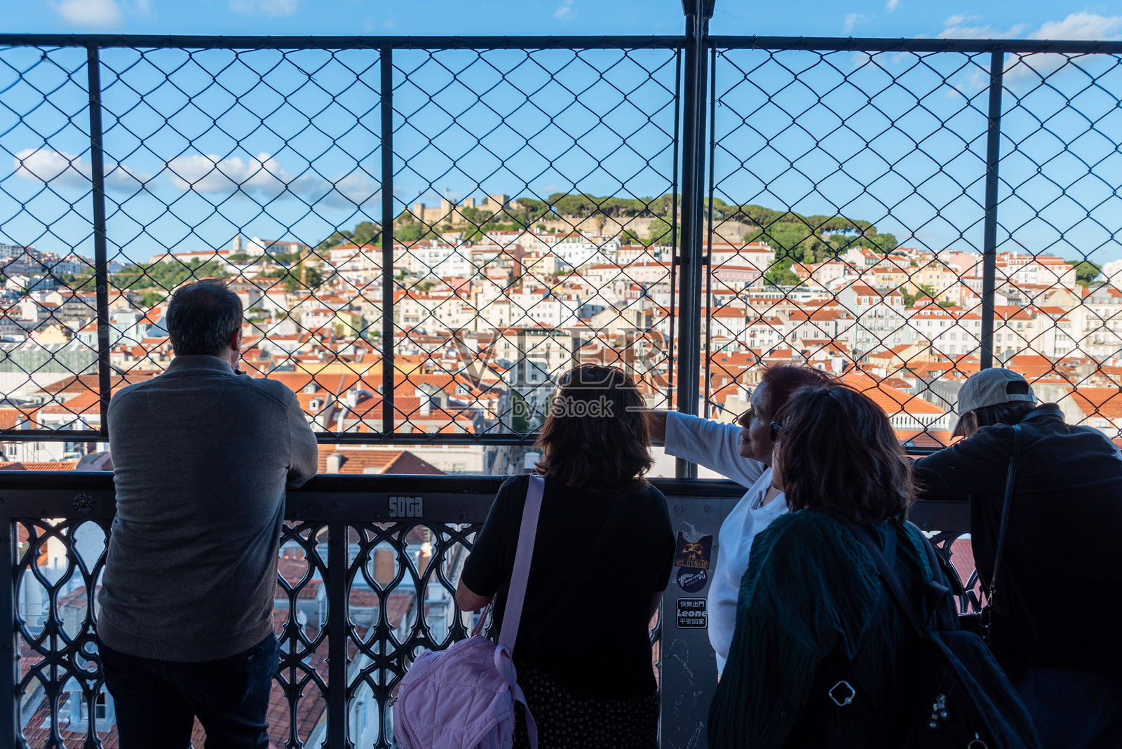 游客们在标志性的圣胡斯塔电梯上欣赏里斯本老城区和圣乔治城堡的美景照片摄影图片