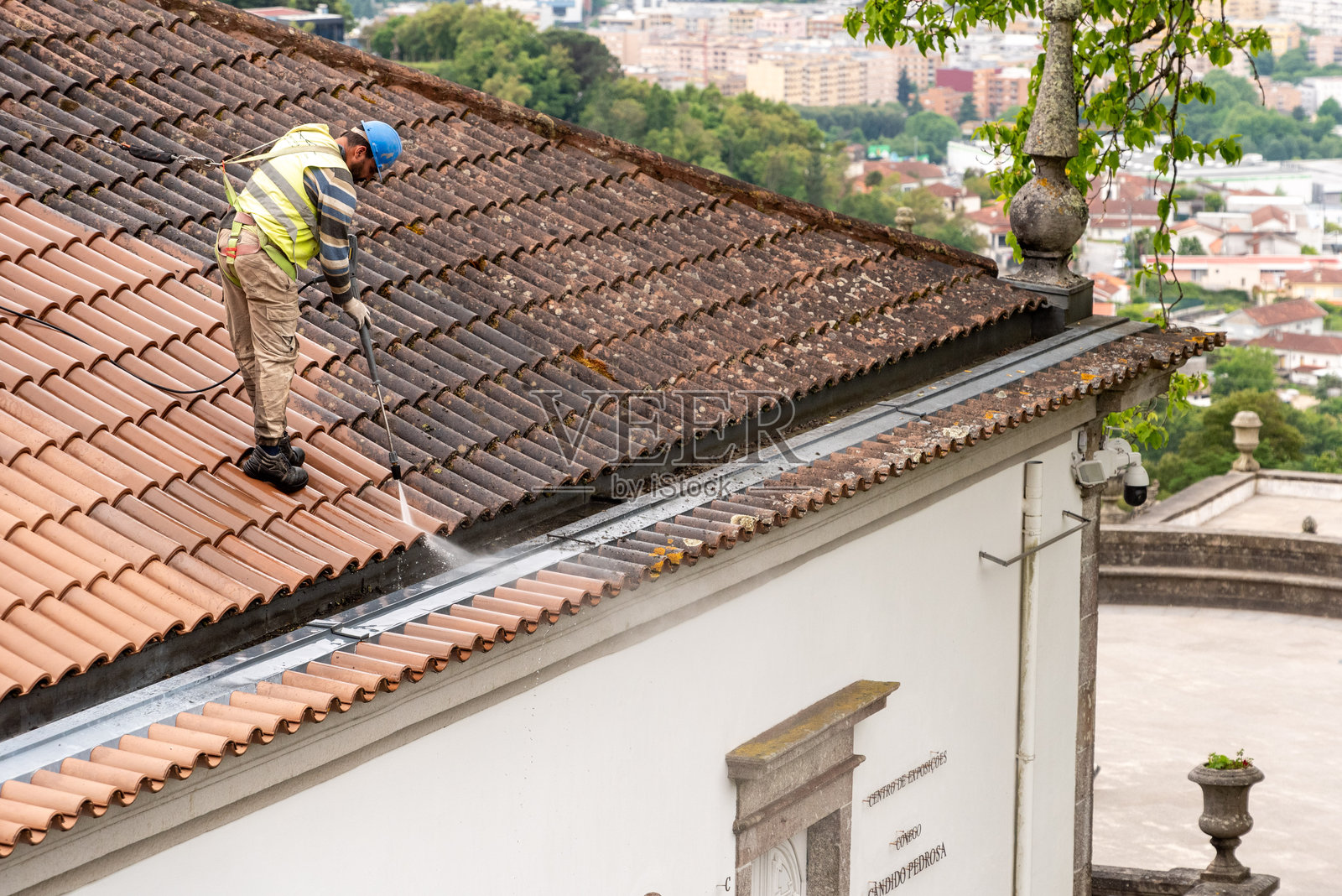 工人在布拉加的联合国教科文组织世界遗产教堂博姆耶苏斯·杜·蒙特清洁屋顶瓦片照片摄影图片