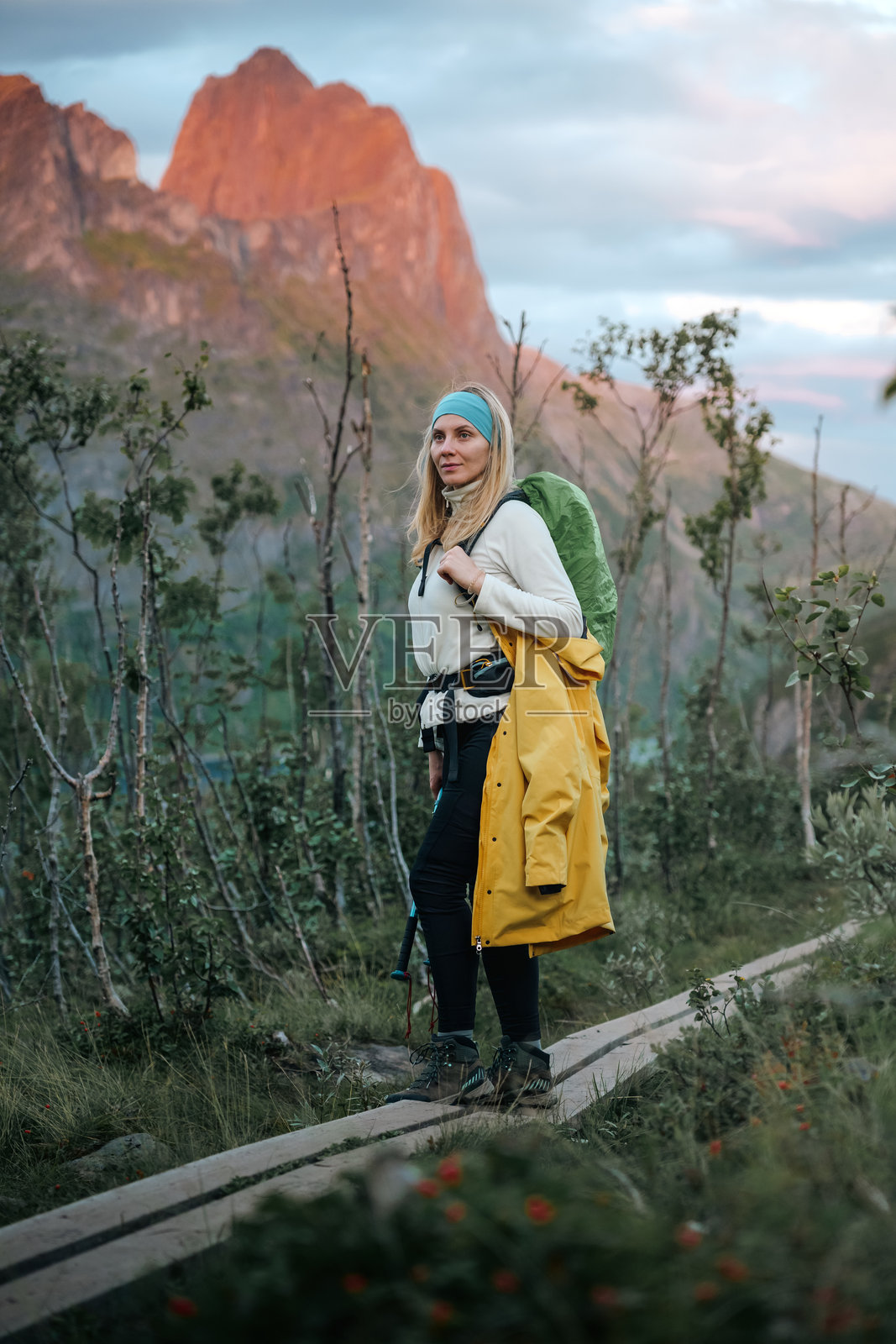 一位女性徒步旅行者在大自然中享受探索风景如画的山间小径的美丽，背着背包。照片摄影图片
