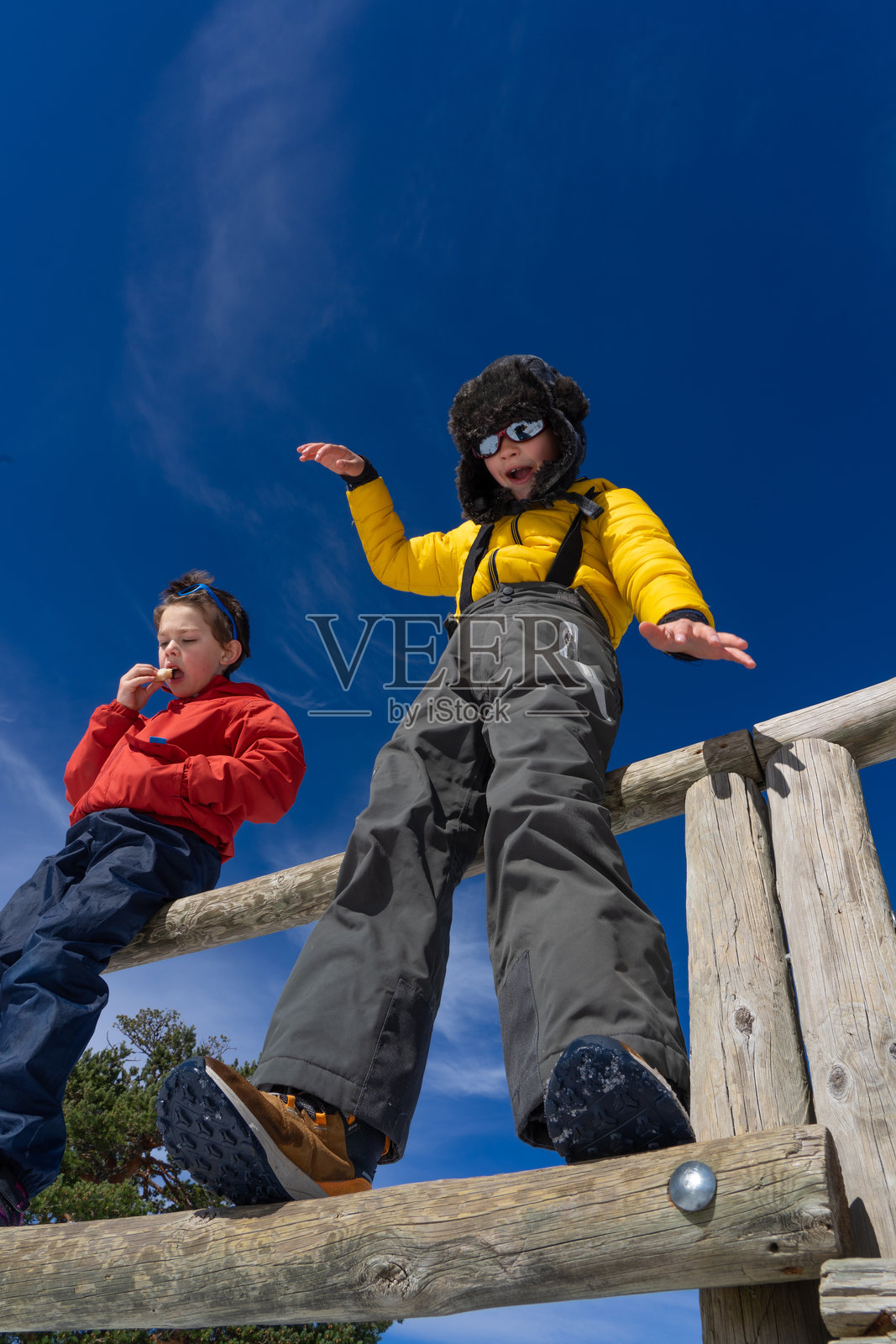 两个孩子穿着滑雪服在雪山上度过一天照片摄影图片