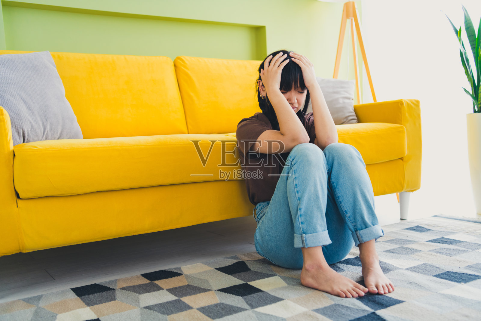 一位漂亮的女士在家中穿着休闲T恤，感到头痛，显得很紧张。照片摄影图片