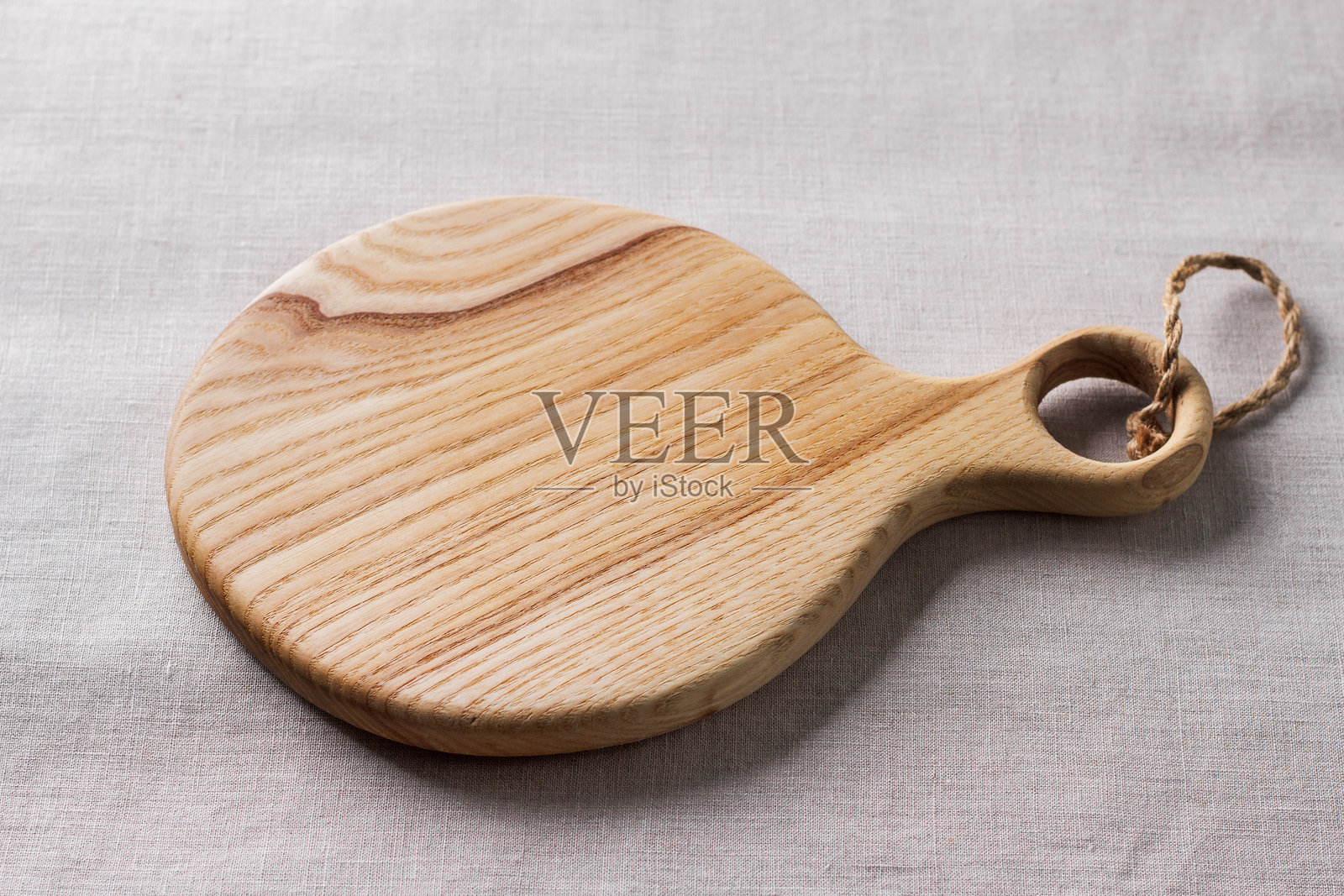 空的木质切菜板放在灰色编织桌布上，创意设计的样板照片摄影图片