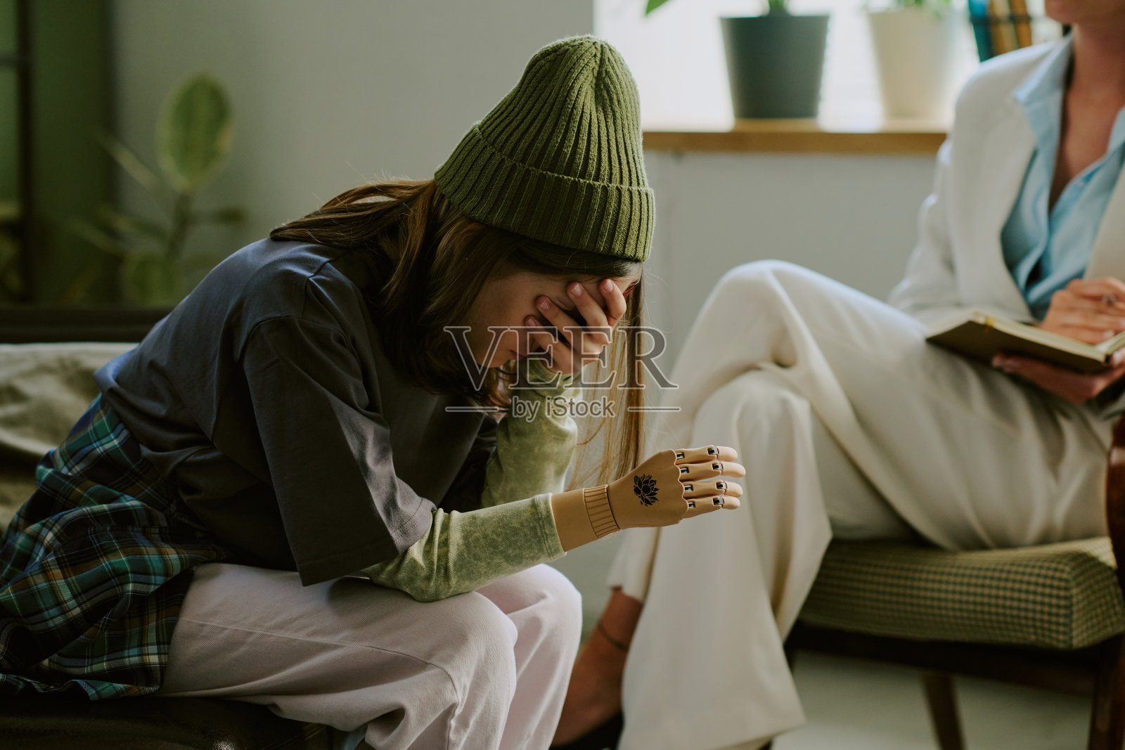 年轻女性用手遮住脸，情绪痛苦照片摄影图片