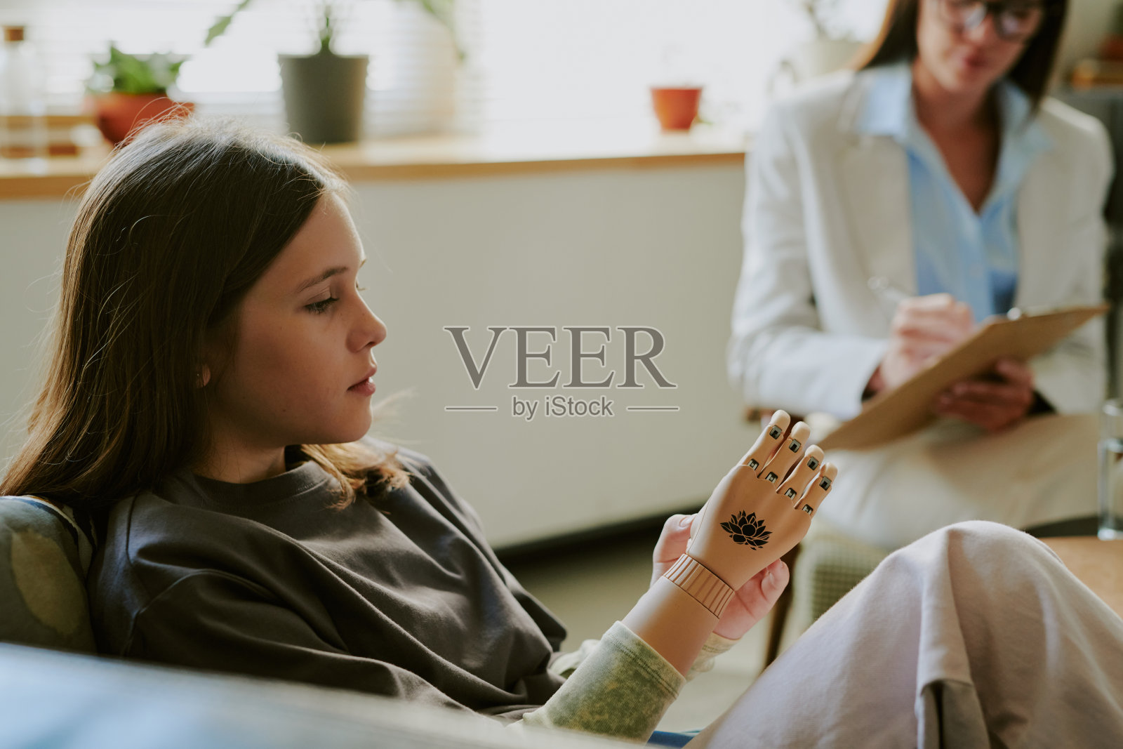 坐着与人交谈的少女，佩戴假手照片摄影图片