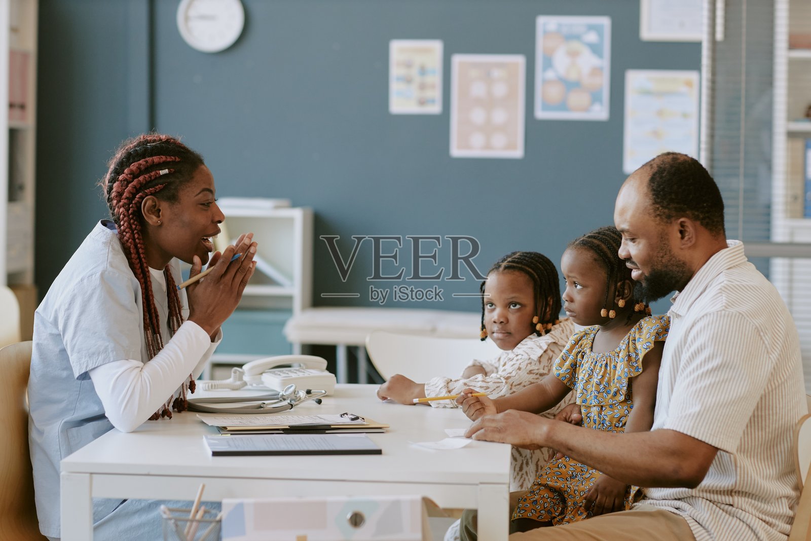在诊所与儿科医生讨论儿童健康照片摄影图片