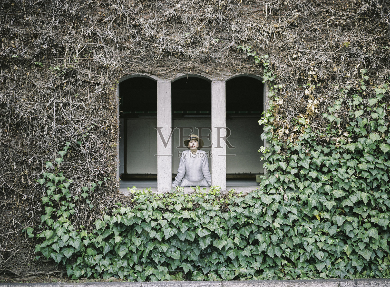 低角度视图的女人站在窗边照片摄影图片