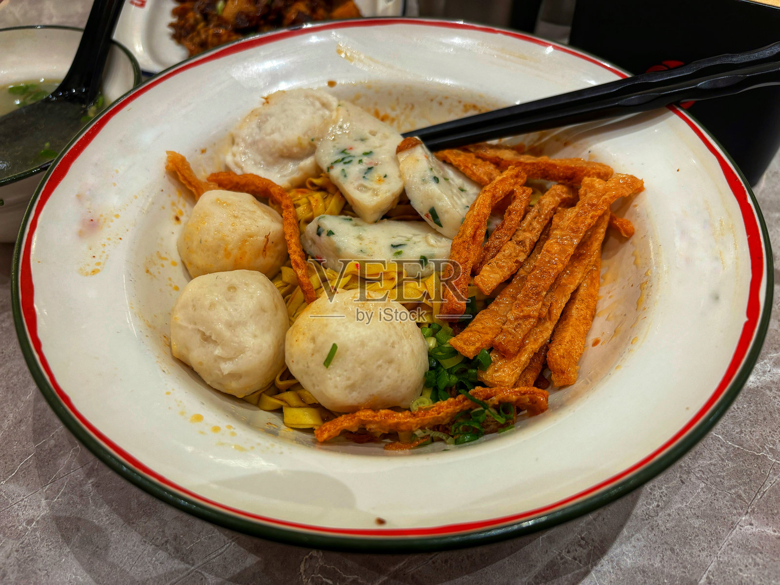 美味的亚洲面条碗，上面放有鱼丸、鱼饼和脆条，突显出一道风味独特的正宗美食。照片摄影图片