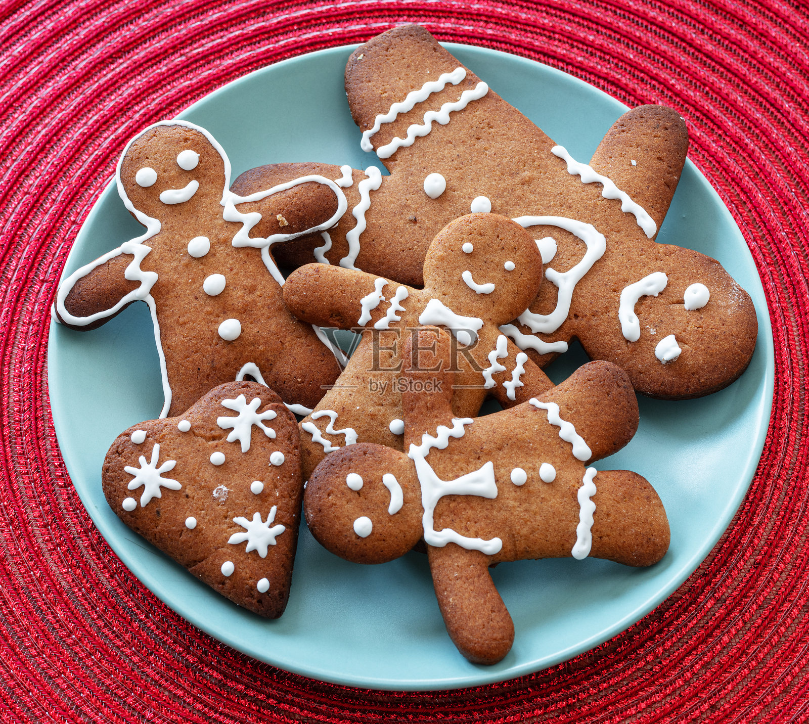姜饼人，蓝色盘子上的圣诞饼干，装饰有皇家糖霜，俯视图。照片摄影图片