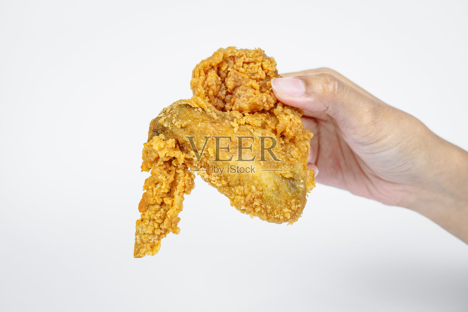 女性手握着炸鸡，背景为白色。照片摄影图片
