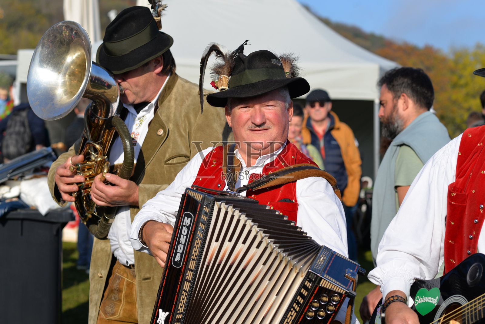 身穿传统奥地利服装的男音乐家在维也纳阿姆希默尔的南瓜集市（Kurbisbauernmarkt Kurbisfest）上。照片摄影图片