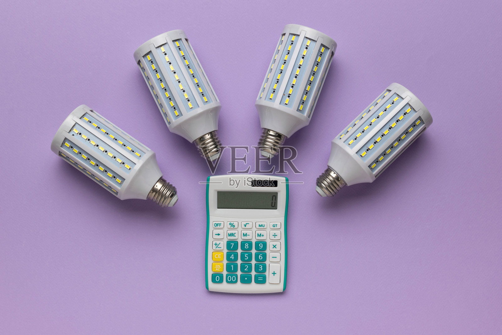 紫色背景上的LED灯泡和计算器的能效计算概念照片摄影图片