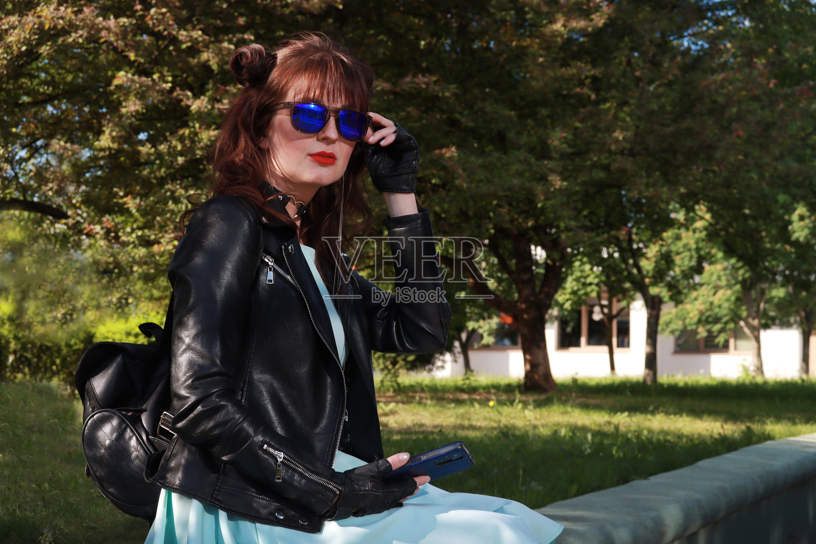 漂亮女孩手持太阳镜看向镜头。照片摄影图片