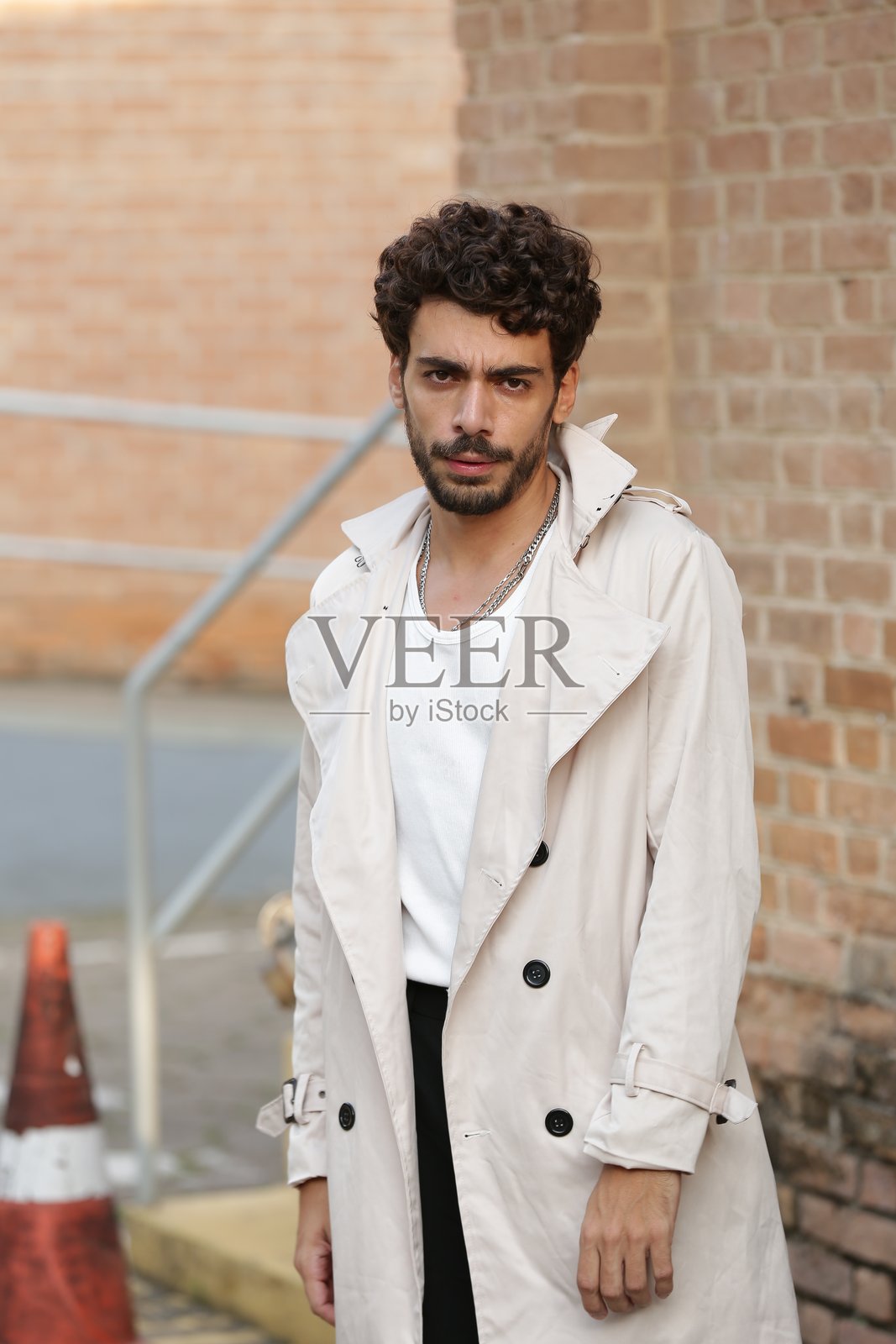 将男性摄影模特风格转变为动态姿势和引领潮流的服装。照片摄影图片