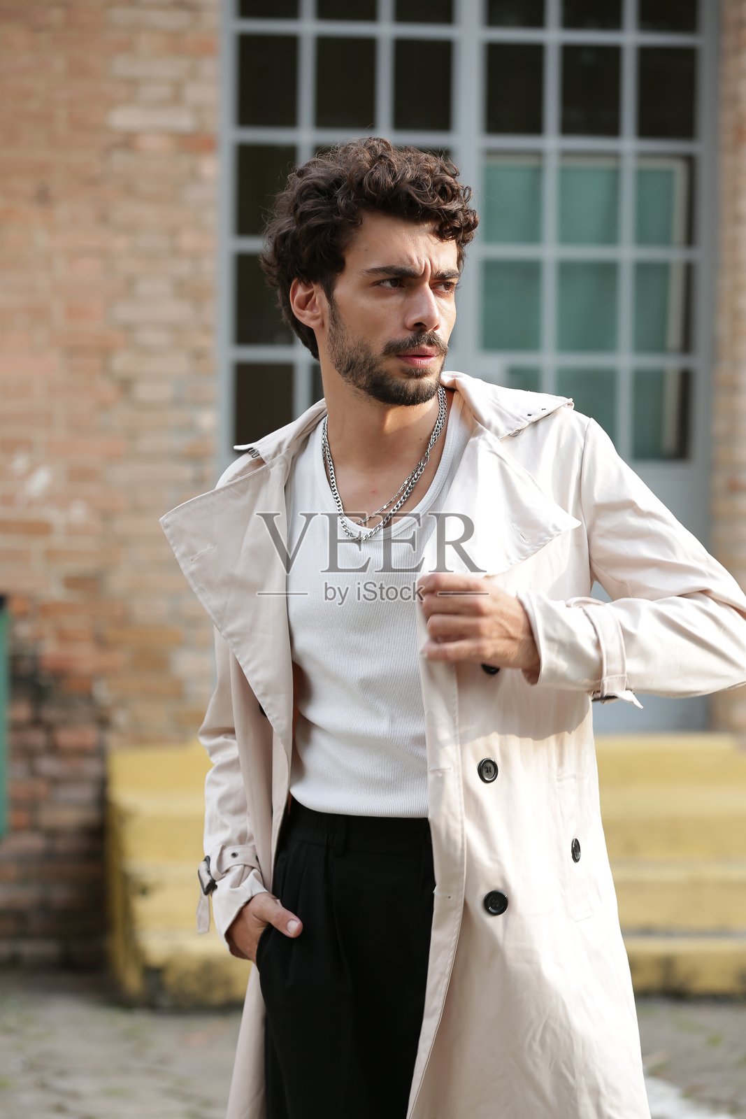 将男性摄影模特风格转变为动态姿势和引领潮流的服装。照片摄影图片