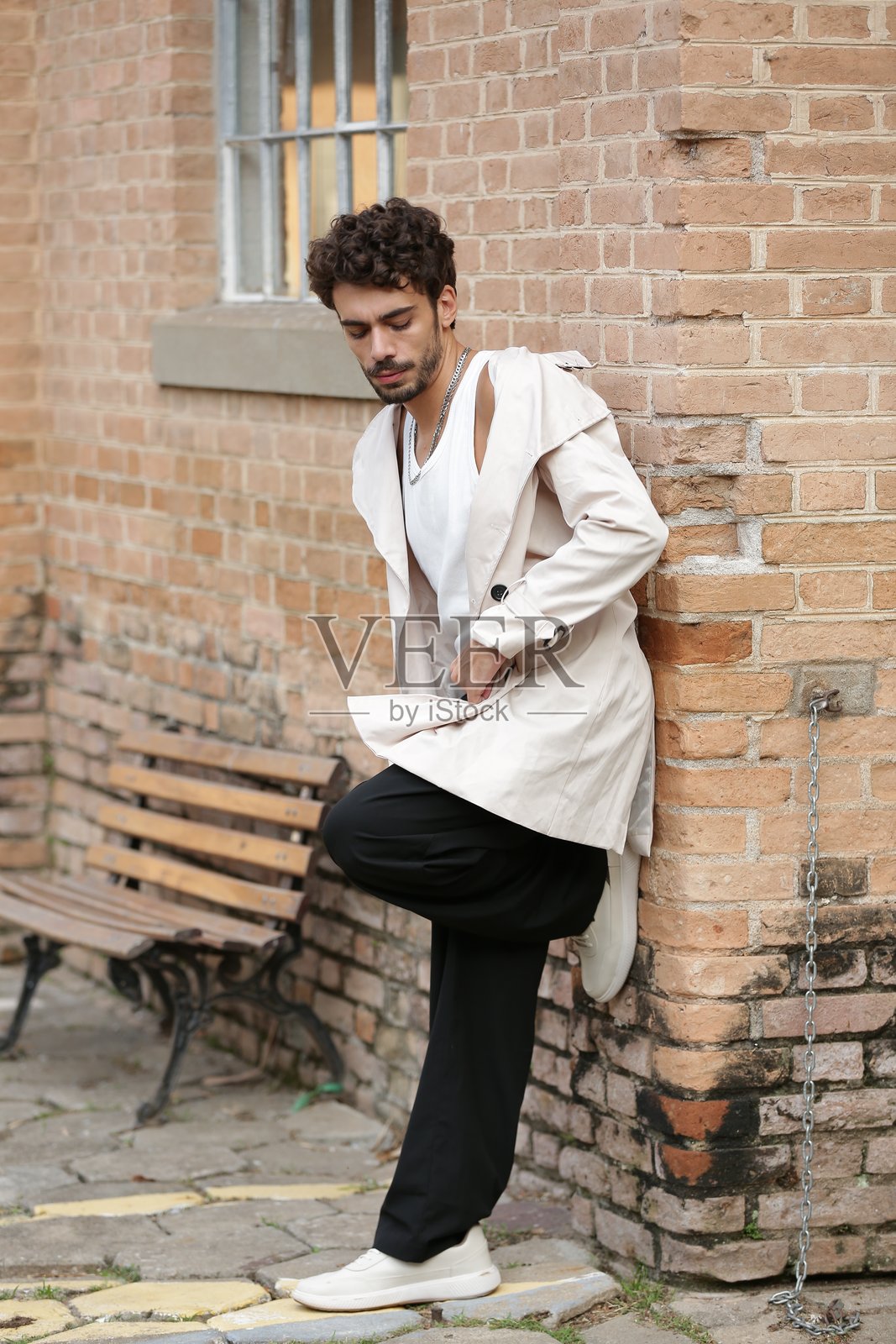 将男性摄影模特风格转变为动态姿势和引领潮流的服装。照片摄影图片