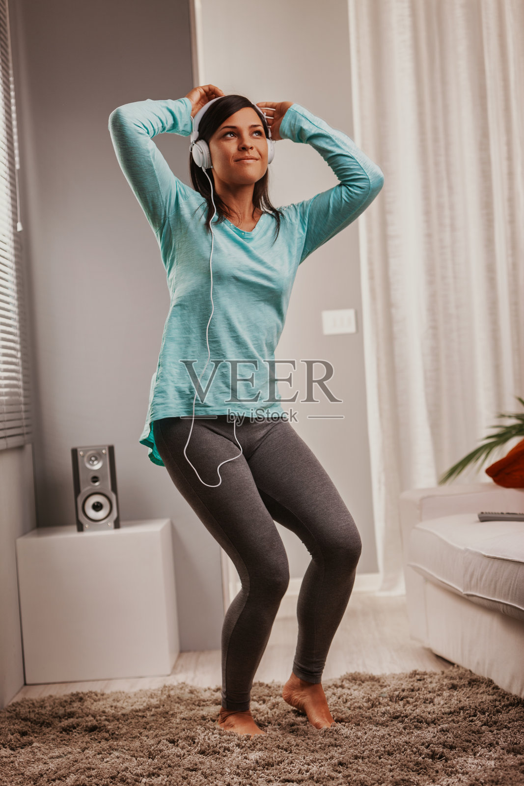 在家中戴着耳机听音乐跳舞的女人照片摄影图片