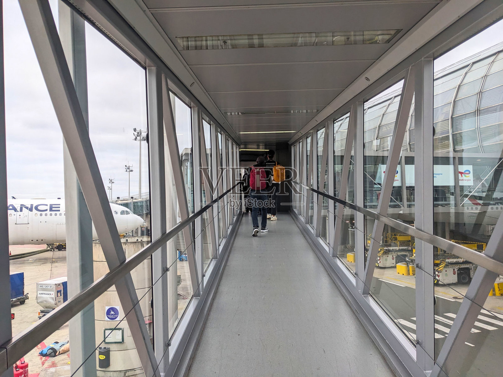 乘客走在登机桥上，前往巴黎戴高乐机场2E航站楼照片摄影图片