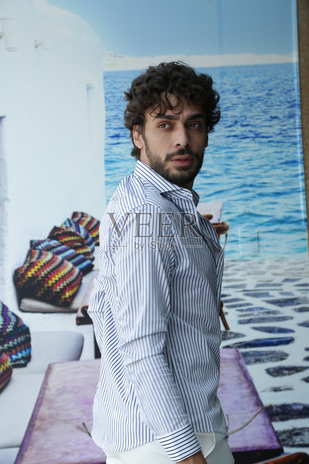 将男性摄影模特风格转变为动态姿势和引领潮流的服装。照片摄影图片