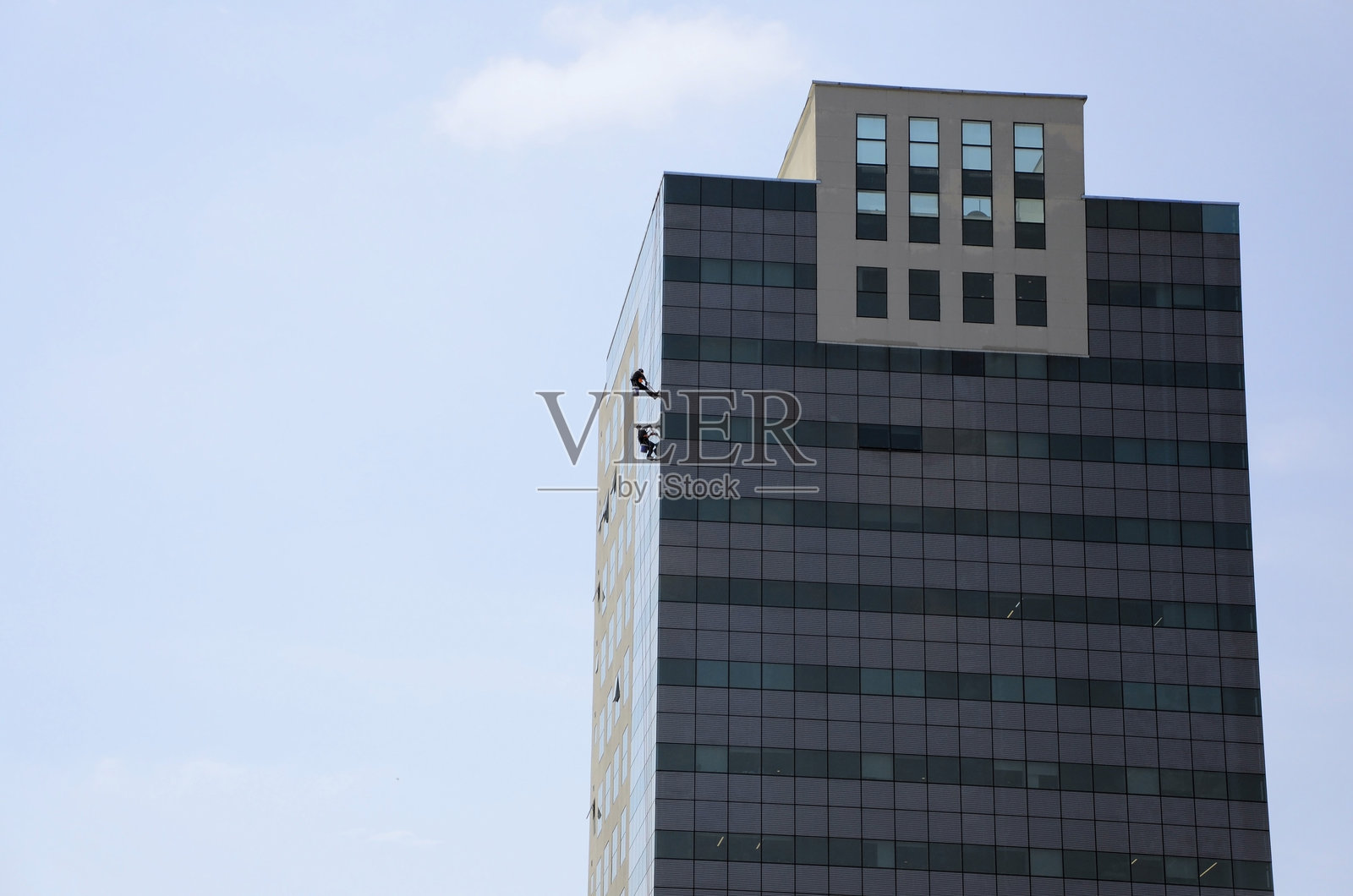 高空作业的工人在清洁建筑物的窗户照片摄影图片