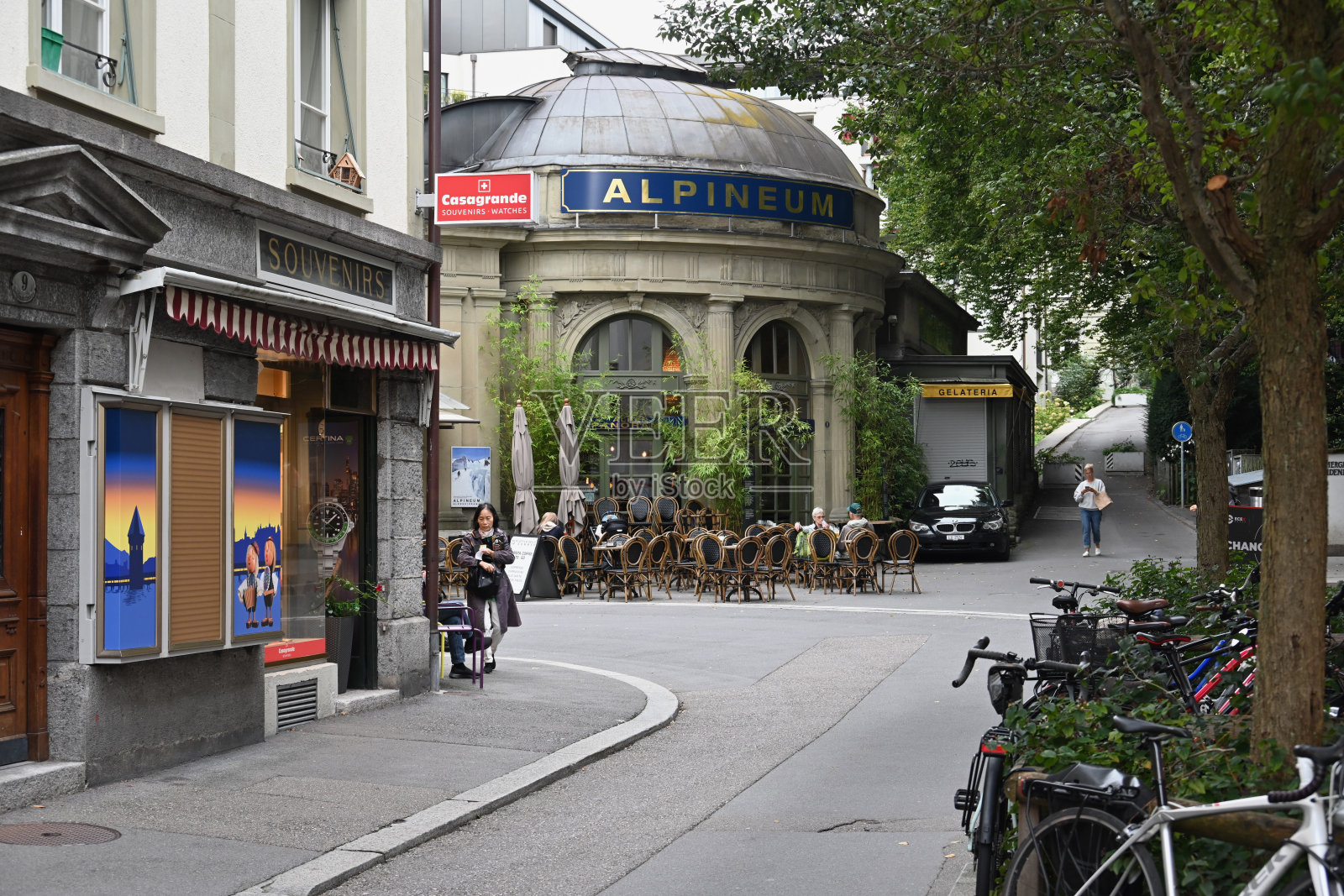 游客和当地人在卢塞恩狮子广场（Löwenplatz）阿尔卑斯博物馆（Alpineum）前的街头咖啡馆里坐着。照片摄影图片