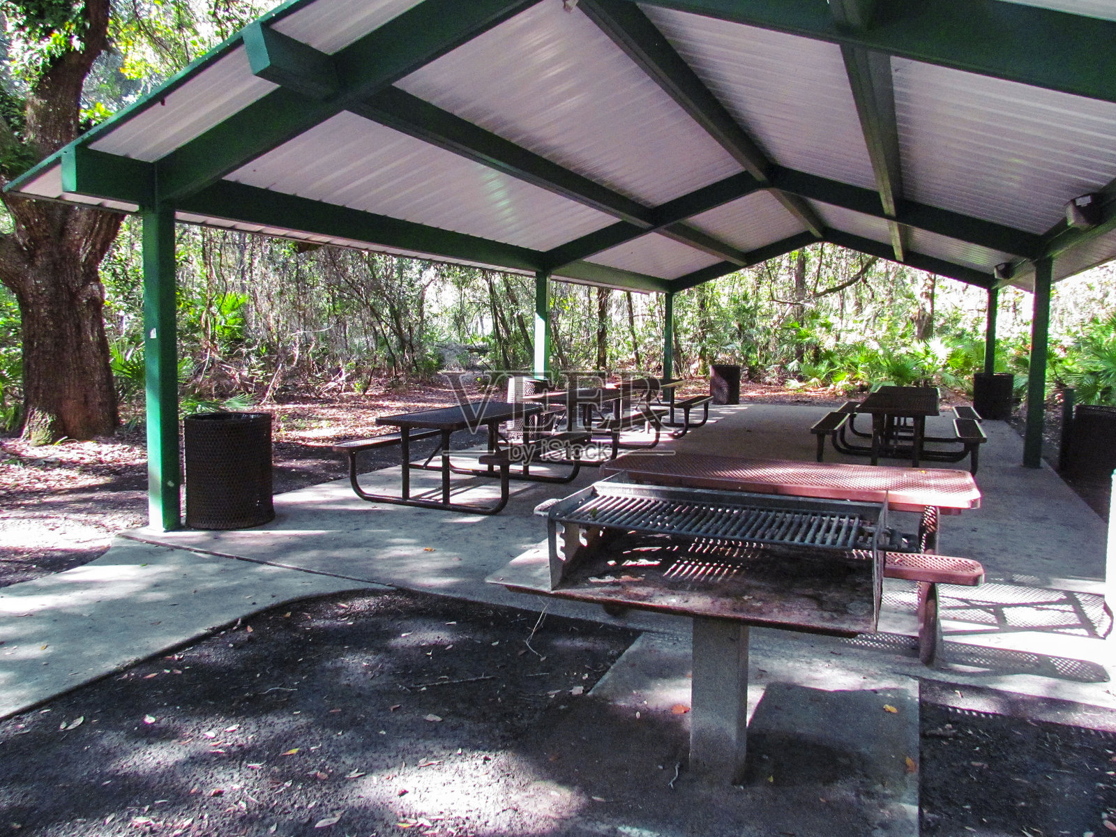 野餐区设有多个桌子和一个烧烤站照片摄影图片