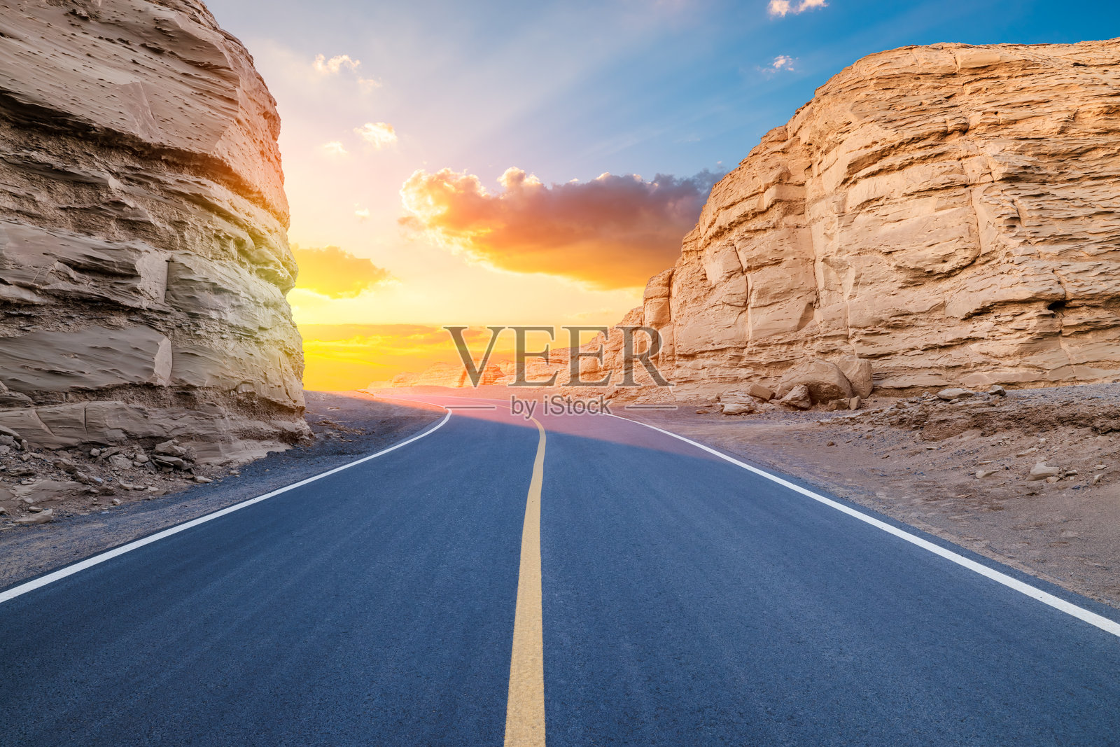 日出时分的沥青公路与雅丹地貌山脉自然风光照片摄影图片