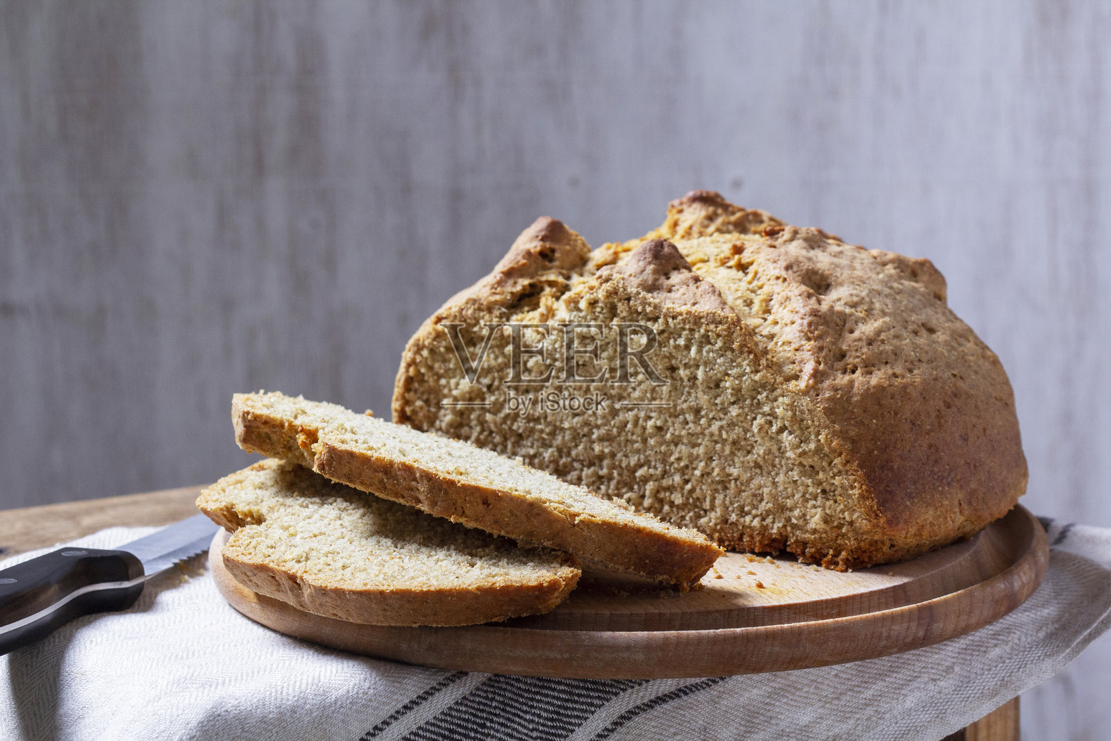 自制的爱尔兰苏打面包切成块，刀放在木质背景上。照片摄影图片