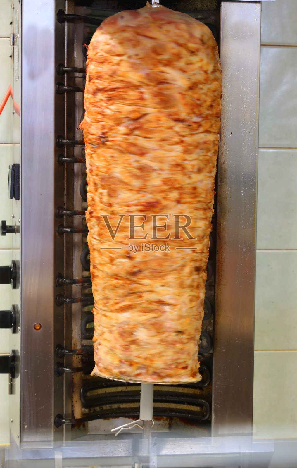 商店里的大型旋转烤肉架，上面挂着熟肉照片摄影图片