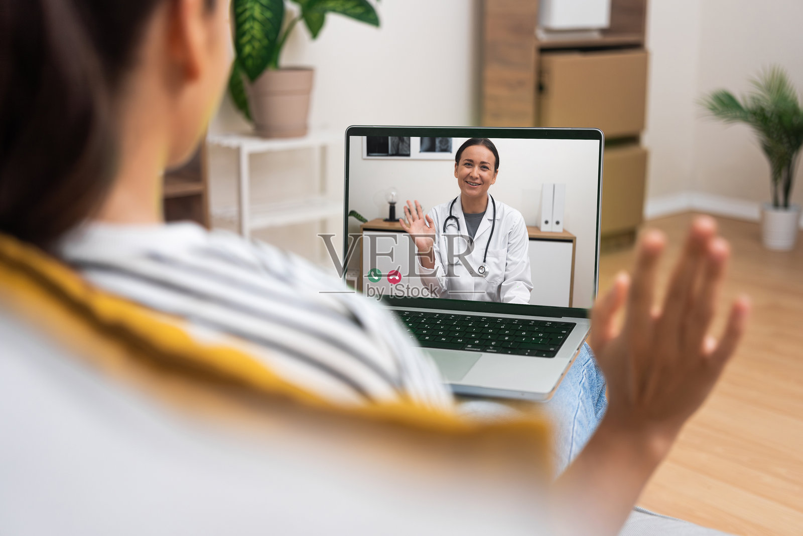 年轻女性与医生进行友好的视频通话，突显远程医疗中的人性化关怀照片摄影图片