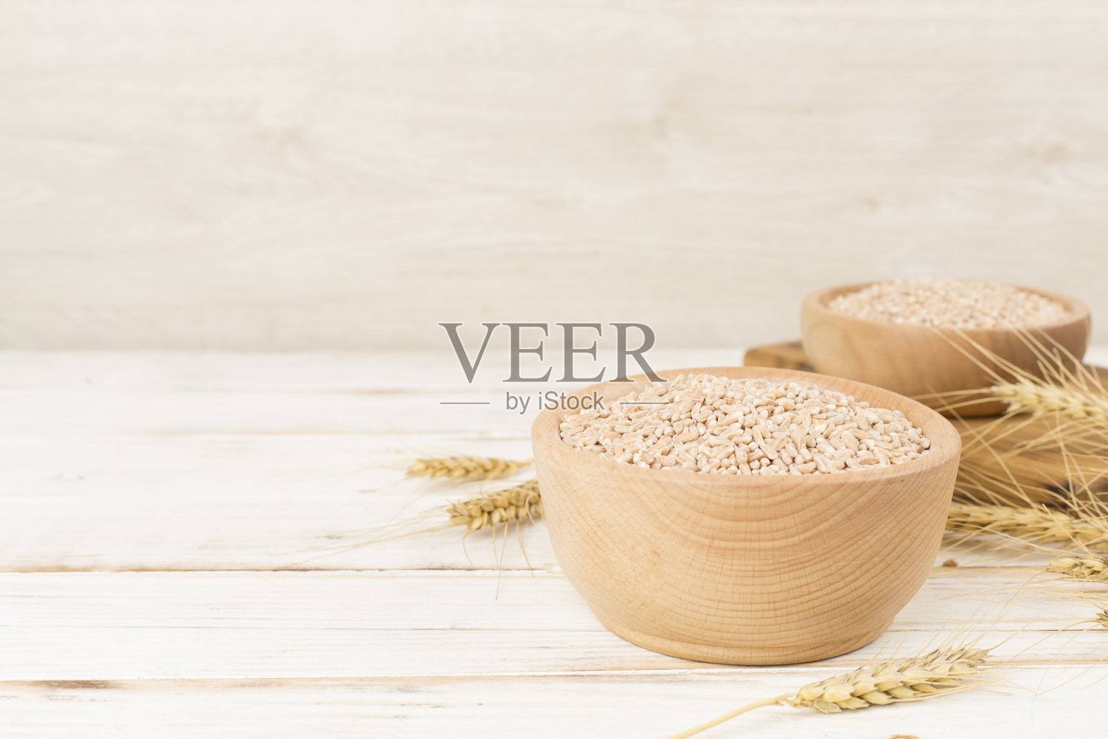 木桌上的一碗斯佩尔特谷物和麦穗照片摄影图片