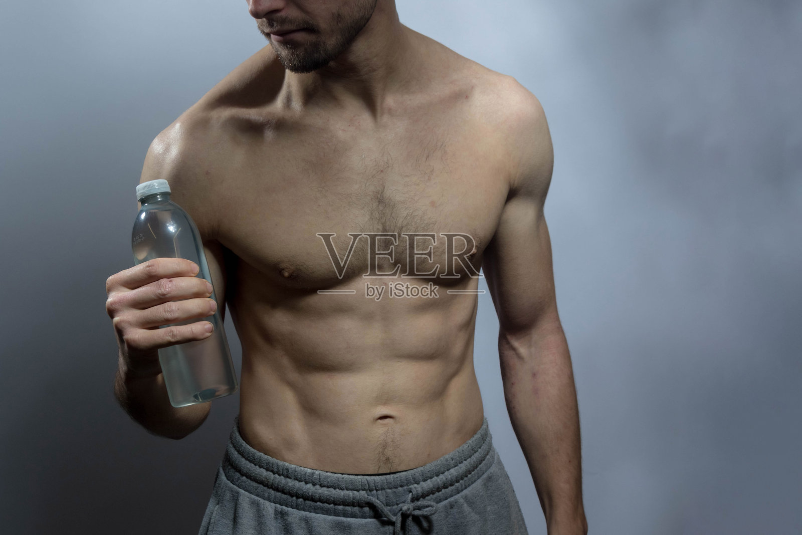 一位年轻的强壮男士，赤裸上身照片摄影图片