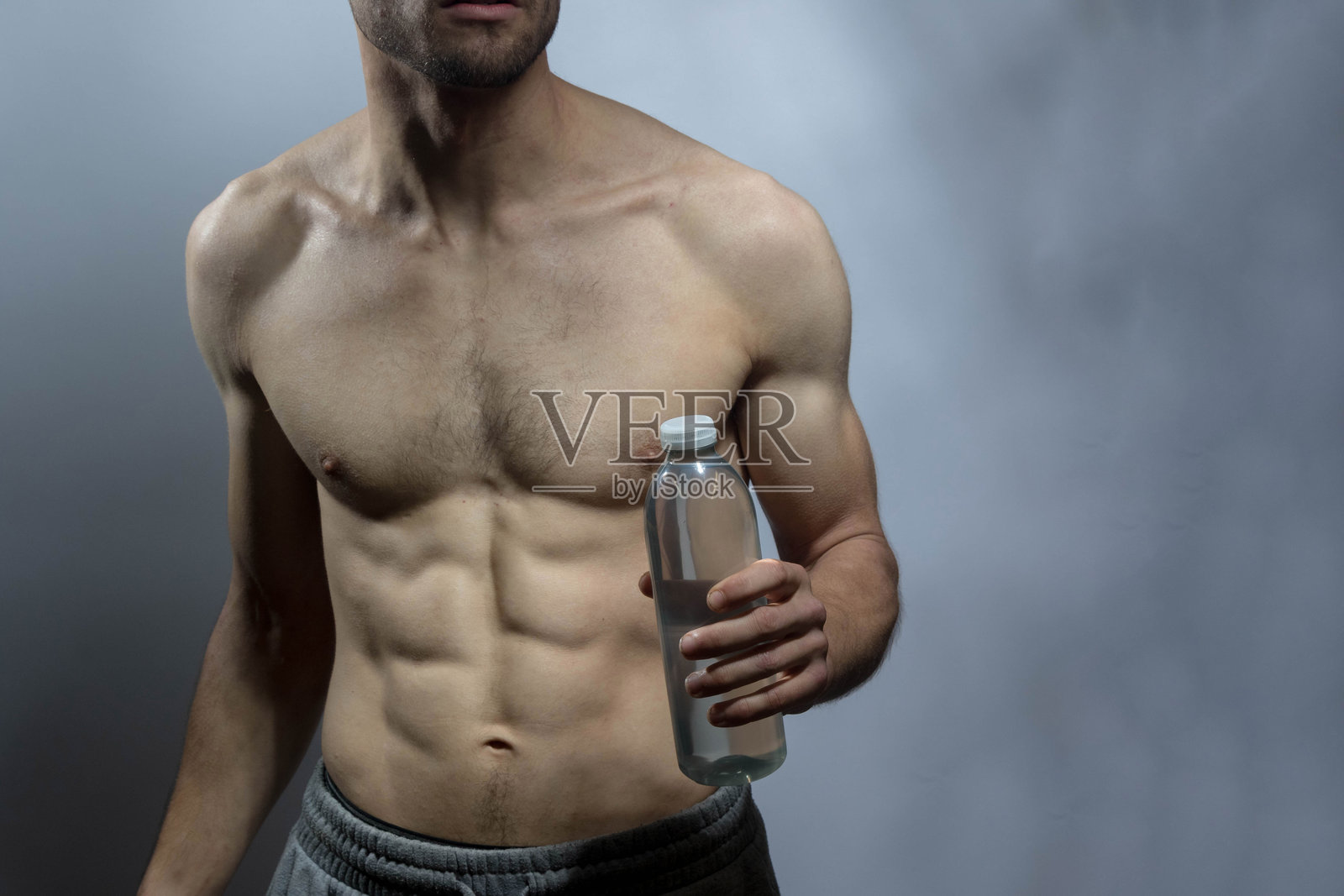 一位年轻的强壮男士，赤裸上身照片摄影图片