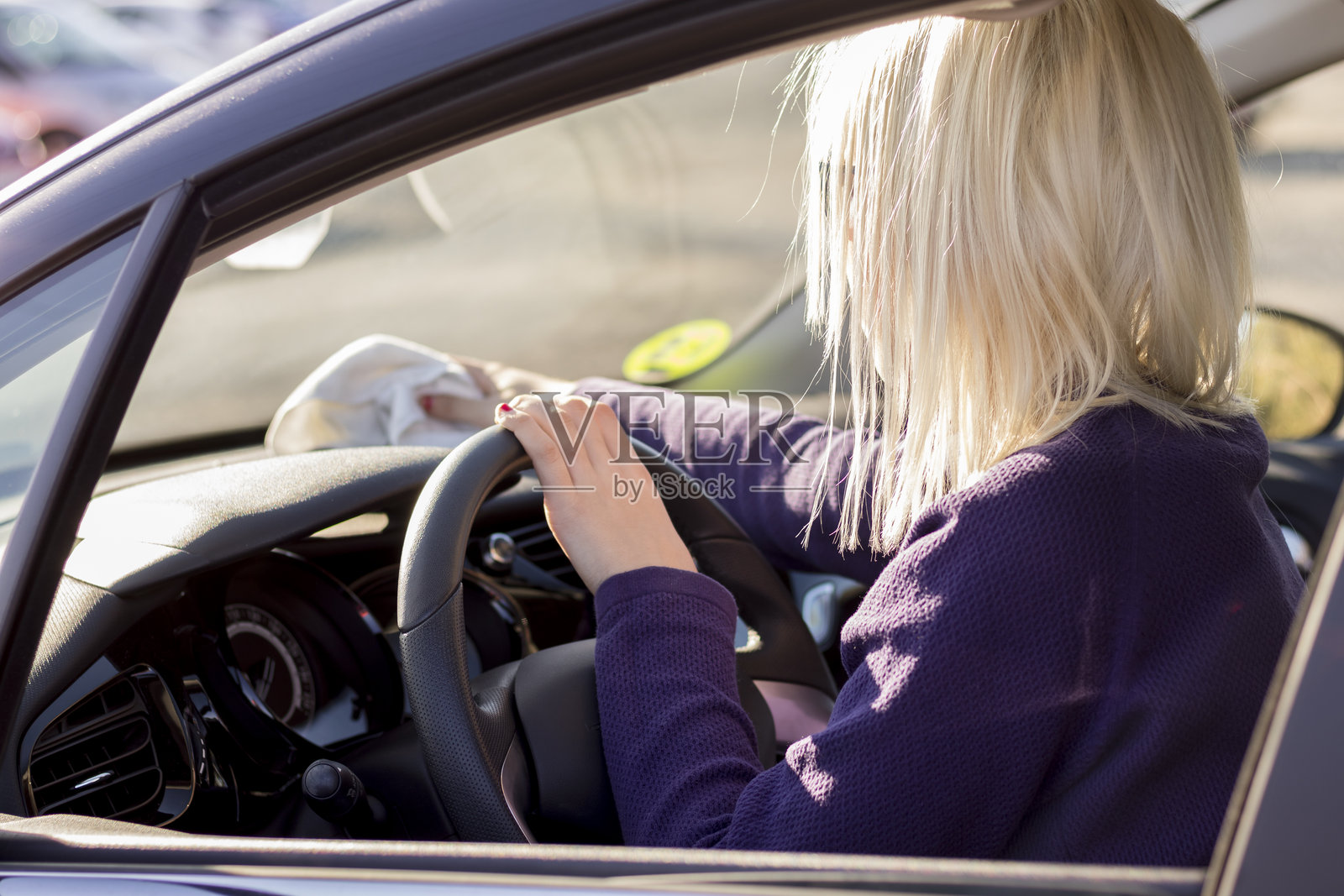 穿紫色上衣的金发司机照片摄影图片