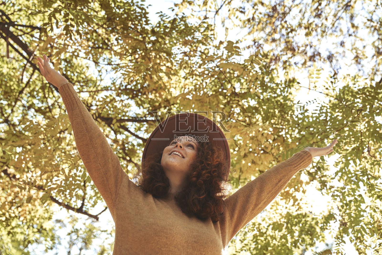 快乐的女人向秋日阳光伸手照片摄影图片