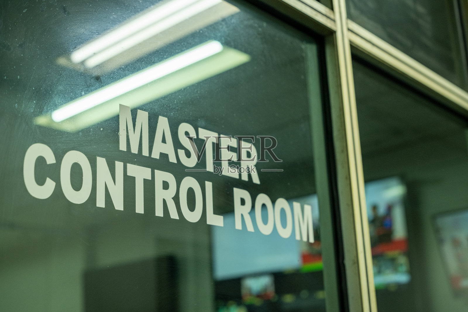 一扇标有“主控室”的玻璃门，指示这是一个配备视频监视器的区域，用于广播技术操作，对于管理直播和制作至关重要。照片摄影图片
