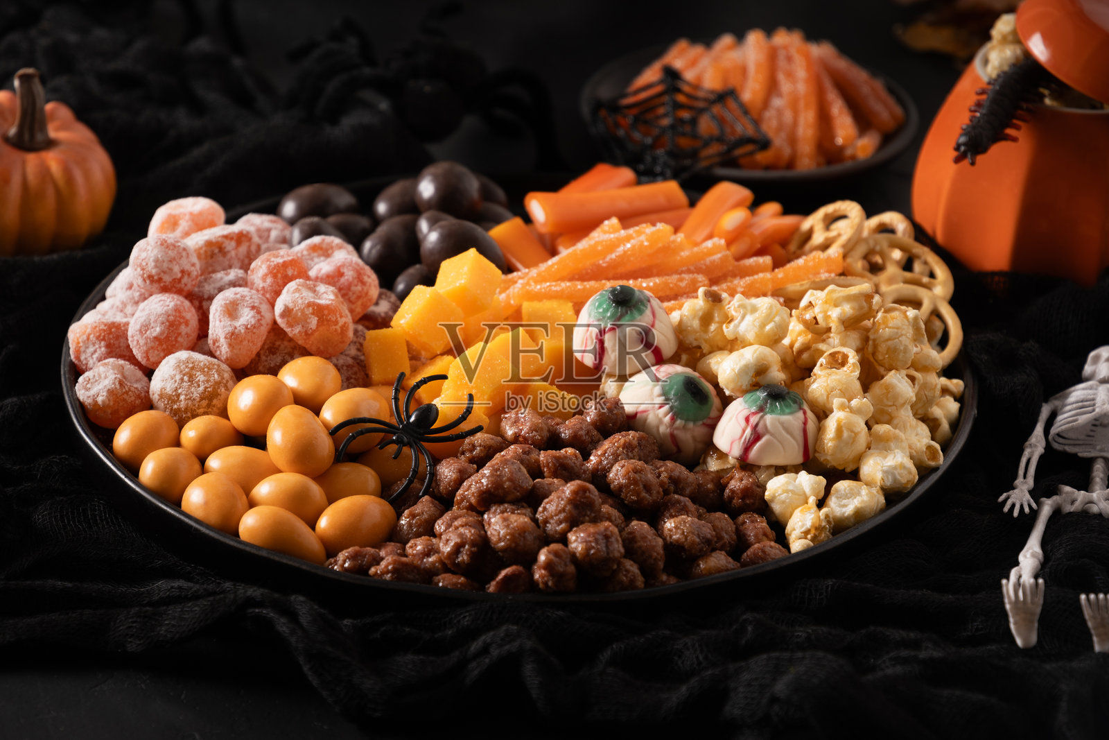 万圣节拼盘，包含南瓜、巧克力糖果、蜘蛛和饼干。照片摄影图片