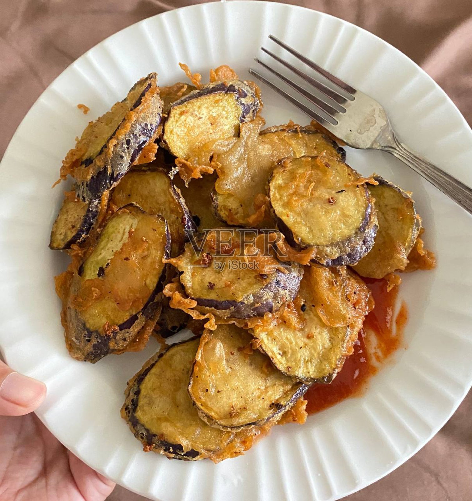 酥脆的炸茄子，金黄色且酥脆，作为美味的小吃或配菜。非常适合食品摄影，展示这种受欢迎的印尼美食的美味口感和风味。照片摄影图片