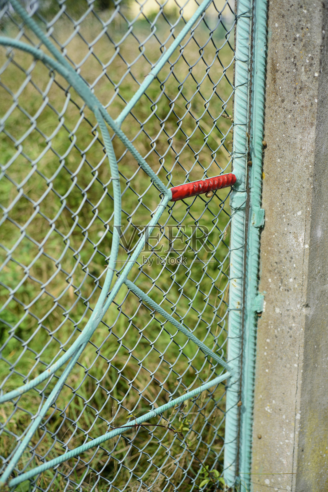 绿色铁丝围栏中的红色物体照片摄影图片