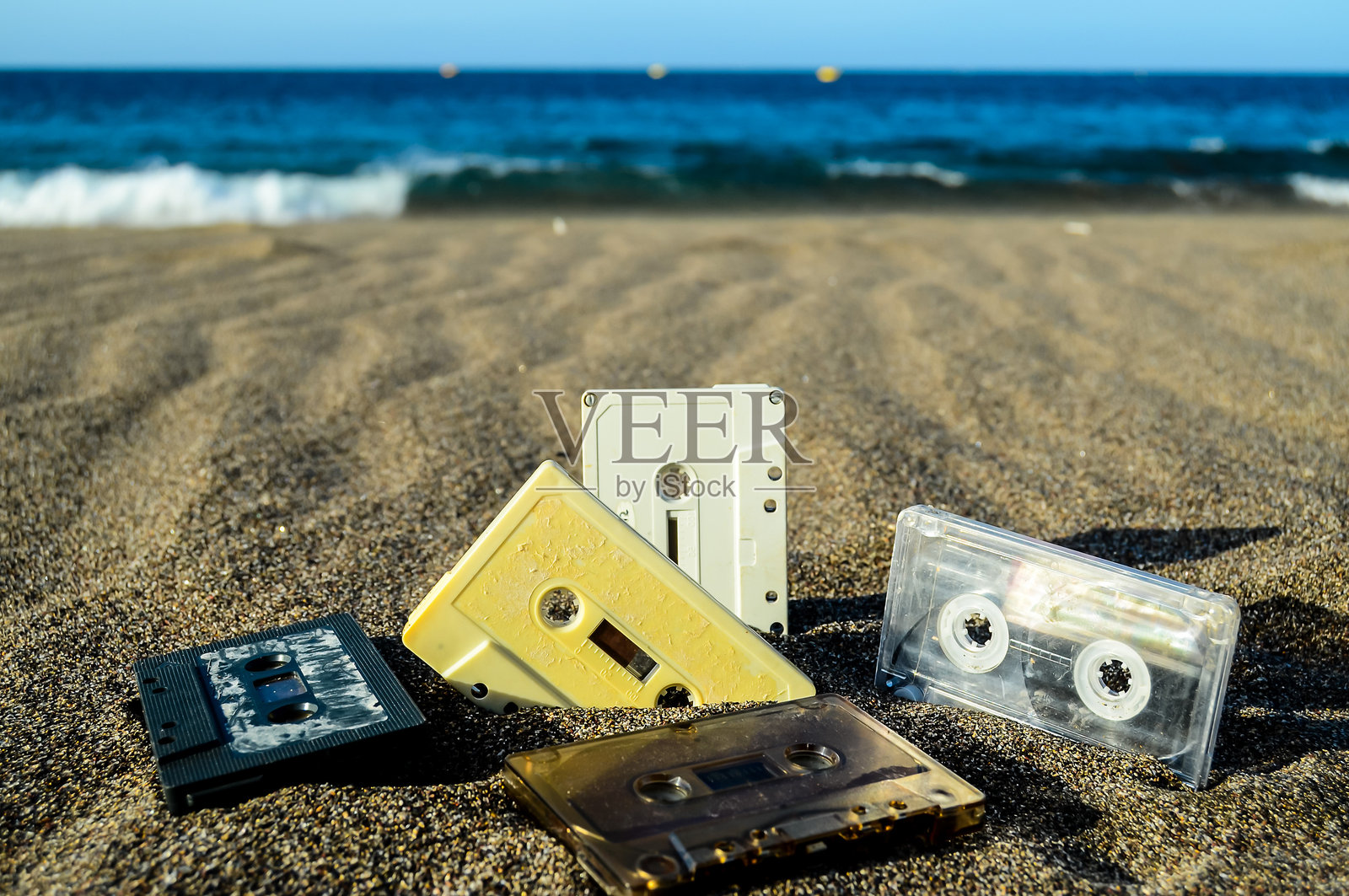一堆旧磁带散落在沙滩上照片摄影图片