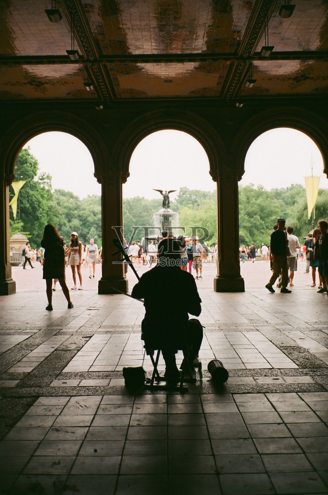 游客与传统二胡演奏者及现代中央公园雕塑的结合照片摄影图片