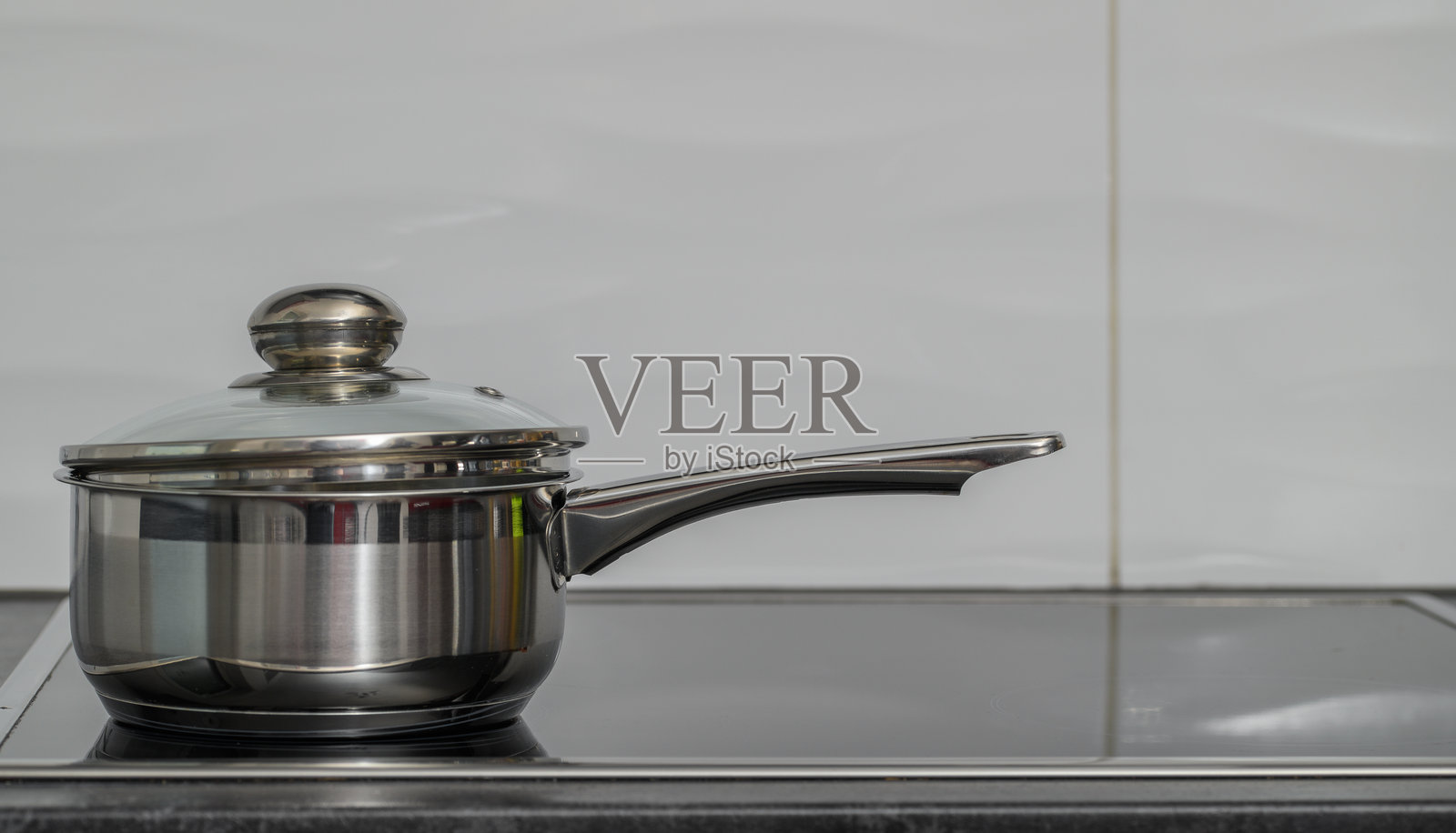 一个不锈钢锅放在家用厨房的电磁炉上照片摄影图片