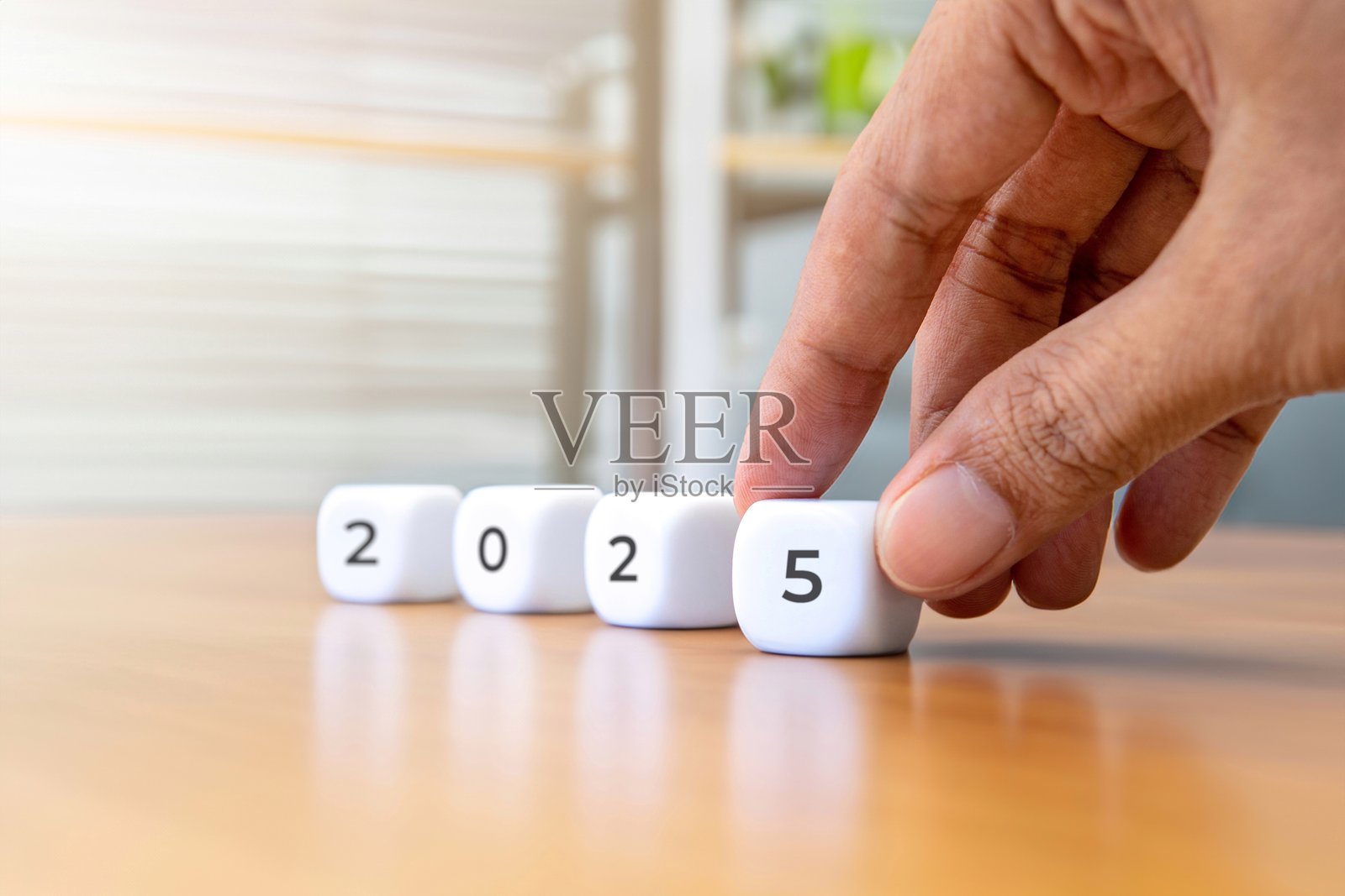 特写镜头，手在摆放一个数字为2025的白色立方体。照片摄影图片
