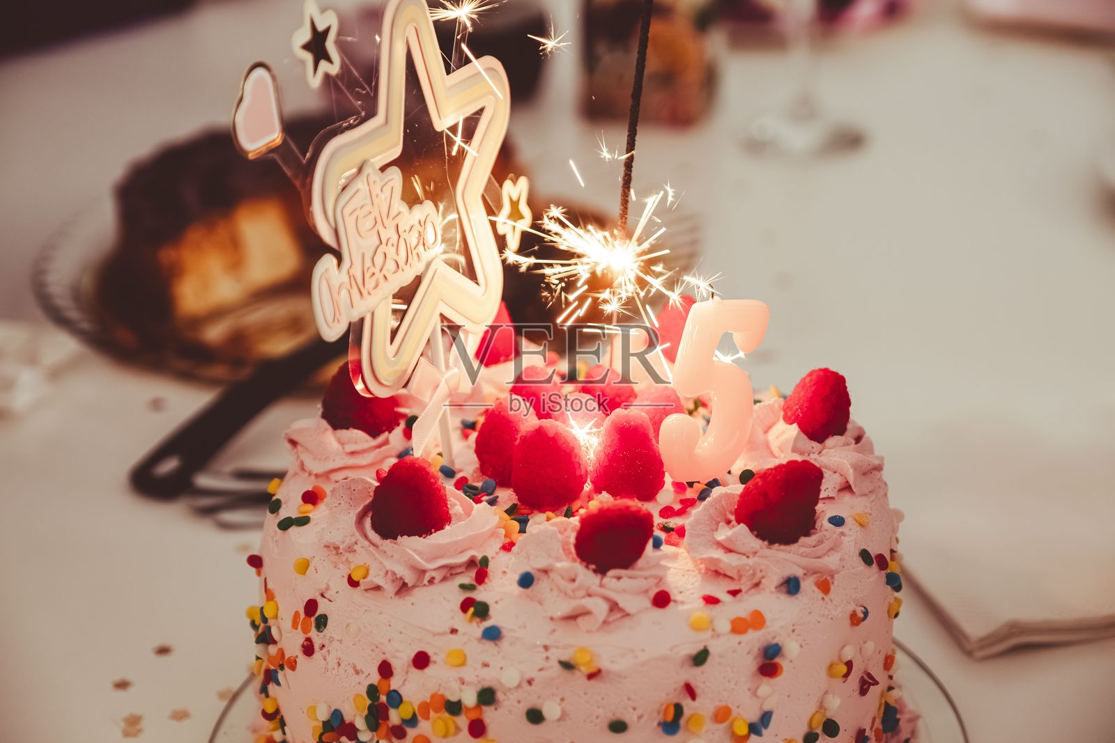 五岁小孩庆祝的五彩生日蛋糕，上面插着一个数字5的蜡烛照片摄影图片