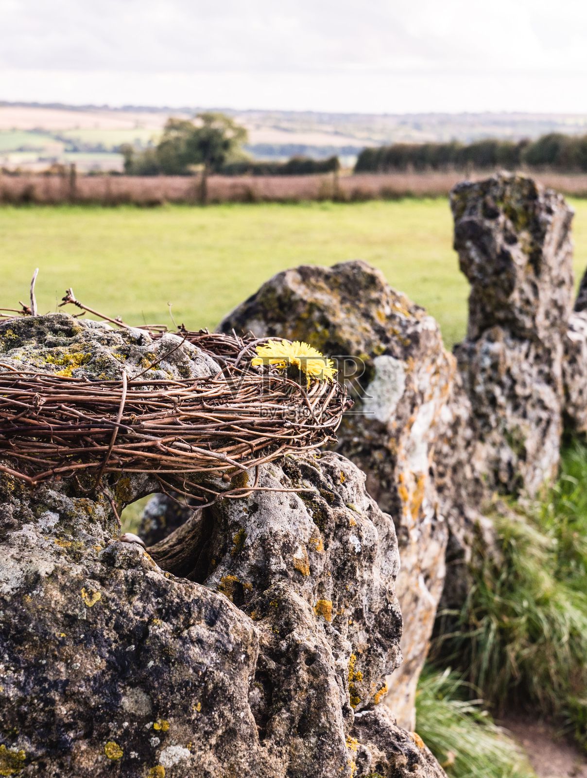 乡村的粗犷石墙上挂着花环和花朵。照片摄影图片