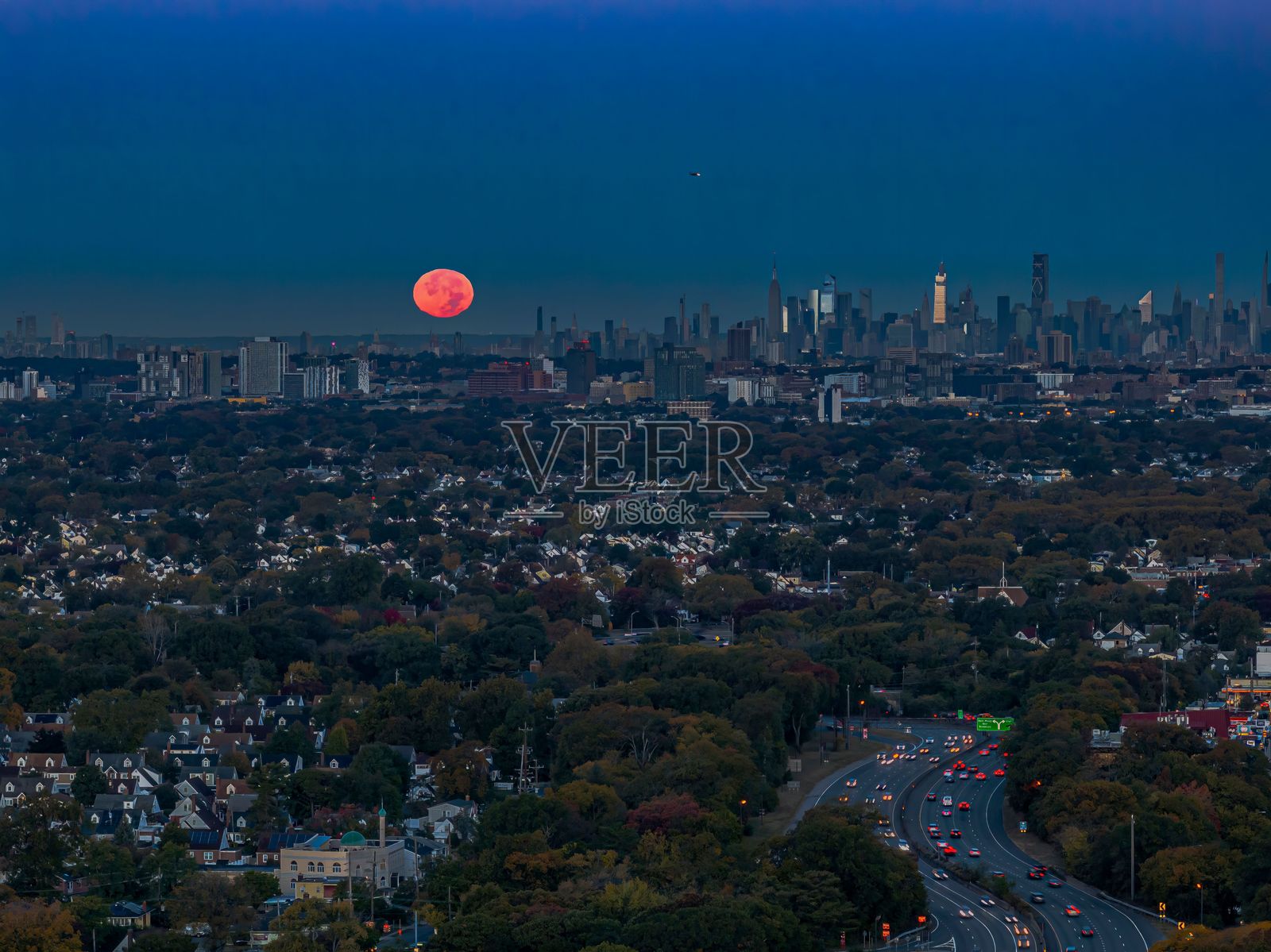 黄昏时分，纽约市天际线与升起的满月。照片摄影图片