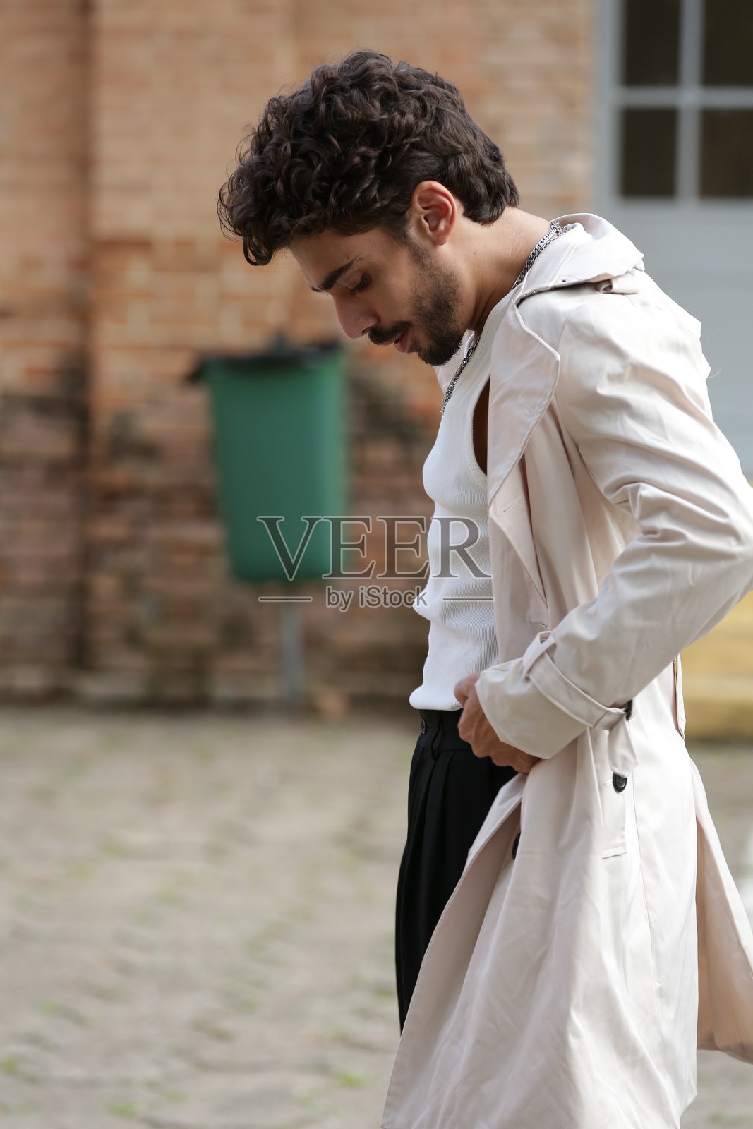 将男性摄影模特风格转变为动态姿势和引领潮流的服装。照片摄影图片