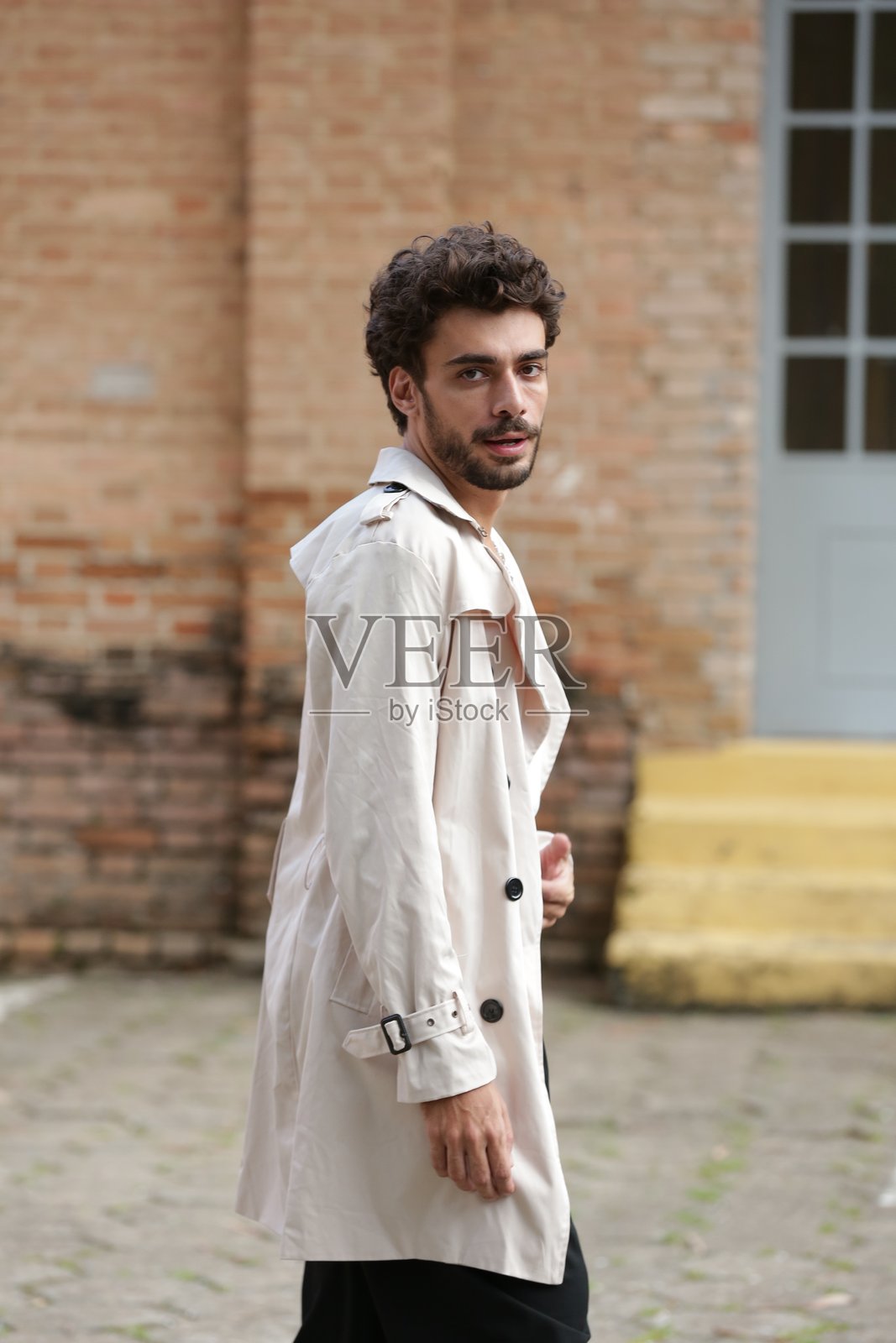 将男性摄影模特风格转变为动态姿势和引领潮流的服装。照片摄影图片