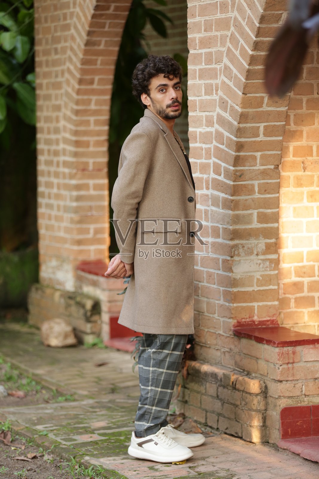 将男性摄影模特的风格转变为动态姿势和定义冬季潮流的服装。照片摄影图片